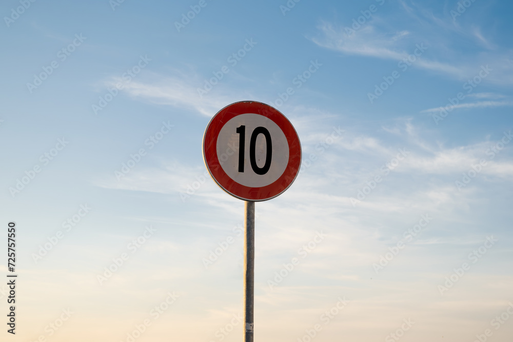 10 miles km maximum speed limit traffic sign isolated with sunset sky