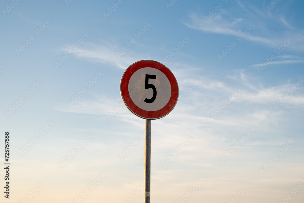 5 miles km maximum speed limit traffic sign isolated with sunset sky