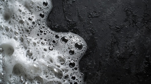 spot of thick shampoo foam on a black background. top view