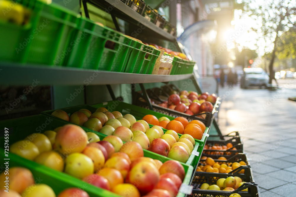 Colorful arrangement of natural organic apples fruits neatly displayed on street store shelves.