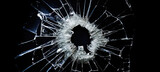 bullet hole in broken glass on black background