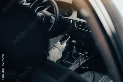 A girl using her phone, while sitting in her car. photo