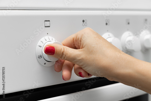 woman turns on the oven in a gas stove.