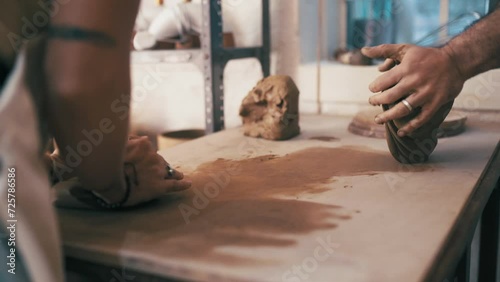 Hands, clay and artists creating in a workshop for ceramic products for small business startup. Creativity, art and closeup of male sculptors working with mud for pottery manufacturing skills in shop photo