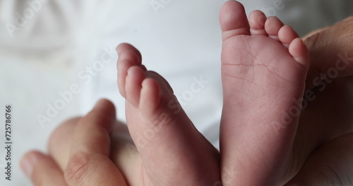 Closeup of newborn baby infant feet and foot in first days of life