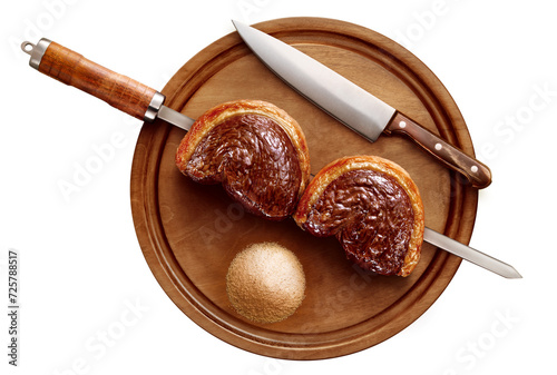 espeto com carne de picanha sobre tábua de servir de madeira acompanhado de farofa e faca visto de cima isolado em fundo transparente - churrasco brasileiro photo