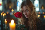A woman's delicate features are illuminated by the soft light of a candle as she breathes in the sweet fragrance of a blooming rose, her portrait exuding grace and serenity against the backdrop of an