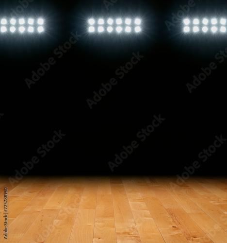 Maple basketball floor with dark background below arena lights