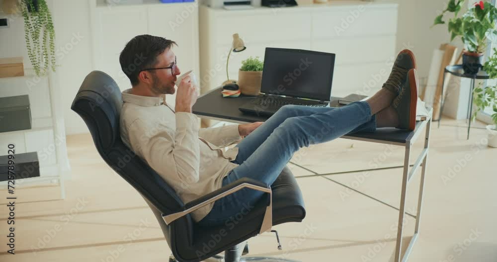 Businessman sipping coffee sitting on office chair Businessman sipping coffee sitting on office chair