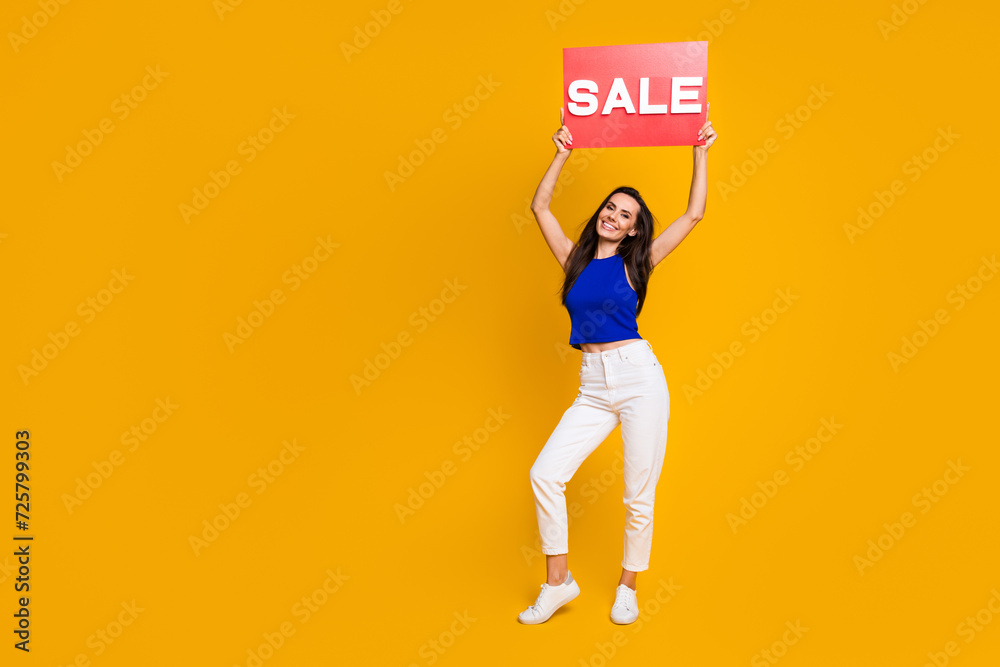 Full length photo of adorable shiny lady dressed blue top rising sale card empty space isolated yellow color background