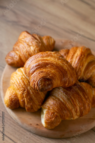 Croissant on a wooden plate on a wooden background