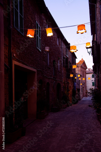Loneliness in a Medieval Village Alley  Lanterns and Colored Lights Illuminate Cobblestone Road - Capturing the Essence of Evening Solitude