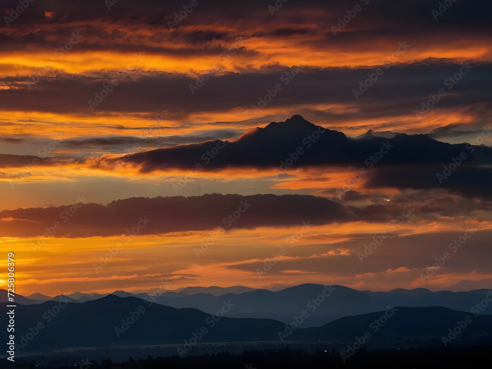 A bright colorful sunset sky over the black silhouettes of the mountains. Dark sunset sky with bright colors over a mountain. Scenic View Mountains Against Sky During Sunset