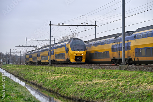 Dutch double-decker trains pass each other in Warmond, Klinkenberg, Sassenheim