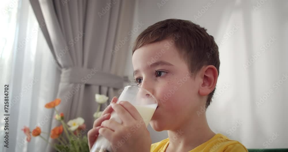 Handsome little boy child drinking milk. healthy eating child eating breakfast kid. Child little boy in kitchen drinks yogurt milk and licks her lips. Happy kid smiling kefir having breakfast. 4K Handsome little boy child drinking milk. healthy eating child eating breakfast kid. Child little boy in kitchen drinks yogurt milk and licks her lips. Happy kid smiling kefir having breakfast. 4K