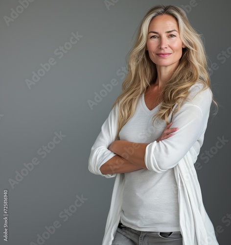 Smiling confident stylish 50s middle aged woman isolated on grey. Older businesswoman, lady executive business leader, manager or entrepreneur looking at camera arms crossed, portrait.