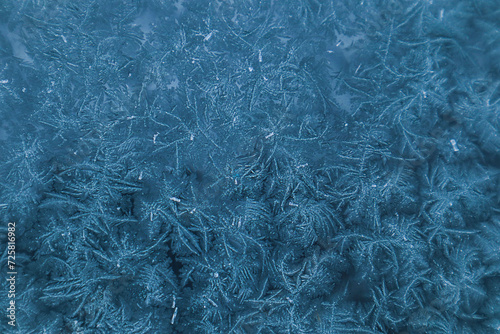 Frosty pattern in blue tones on window glass on a winter day