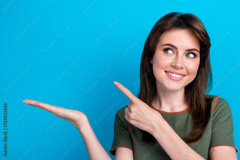 Photo of gorgeous minded lady look direct finger arm hold empty space isolated on blue color background