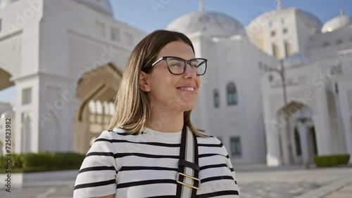 Young woman tourist smiling at qasr al watan palace in abu dhabi, uae, under clear skies photo