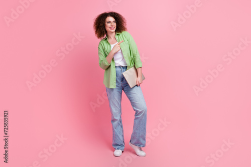 Full length photo of girl introduce her new project she made for month direct finger website hold laptop isolated on pink color background