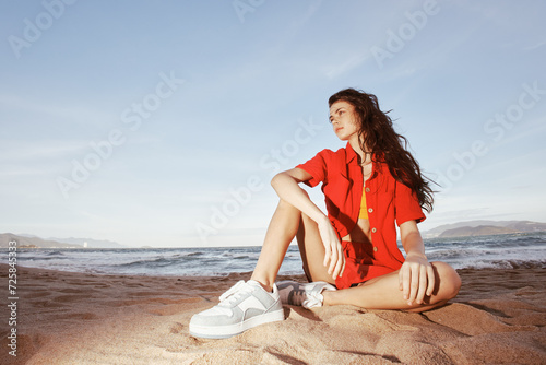 Smiling Woman in Trendy Beach Fashion, Sitting on Sand: Summer Emotion