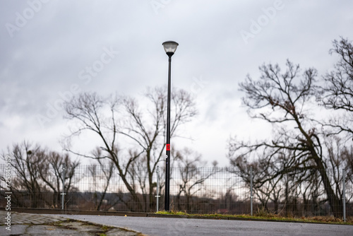 Latarnia na tle zimowych drzew i chmurnego nieba