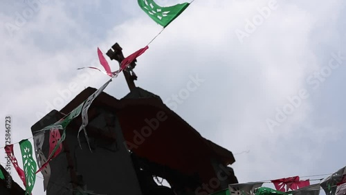 Banderines a vuelo de viento con cruz cristiana al fondo en cámara lenta photo