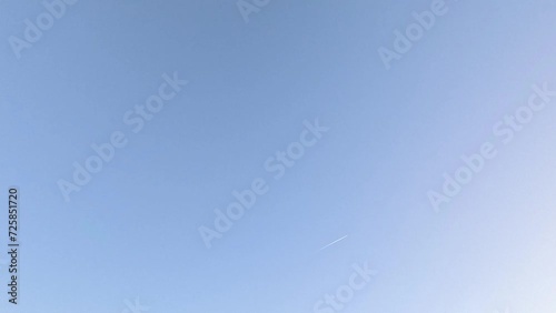 Airplane with contrails in the blue sky photo