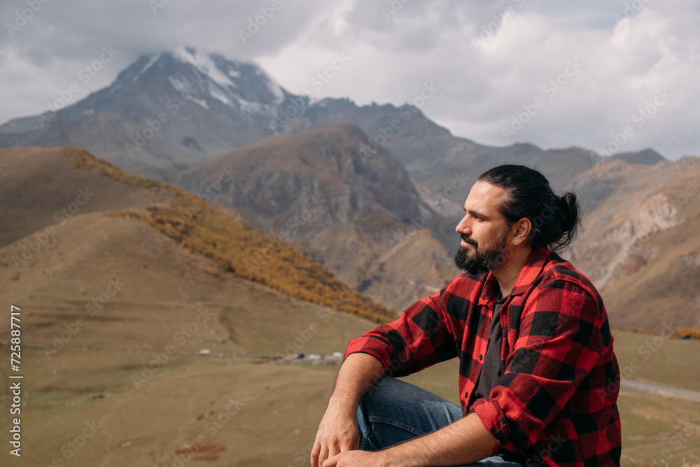 A man on the background of an autumn mountain landscape.