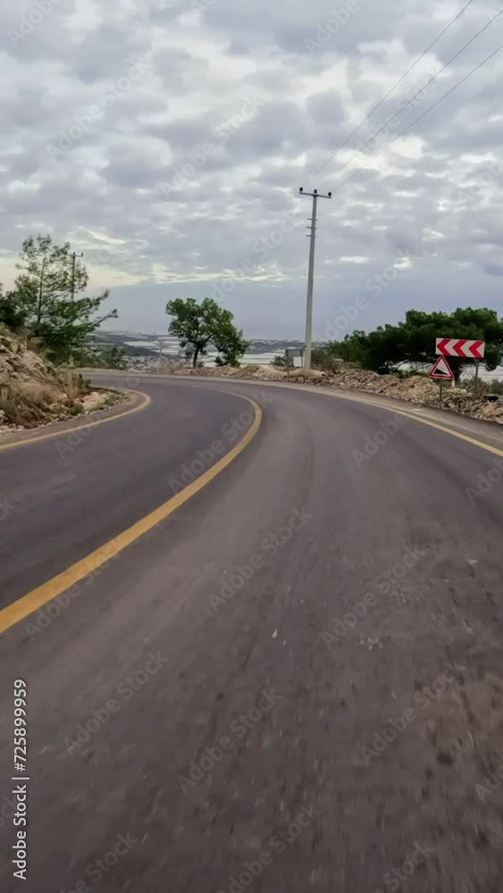 Car takes turns on mountain asphalt road, scenic drive. Sharp turn on asphalt road in mountains, clear blue sky. Asphalt road journey, turning paths in mountainous terrain Car takes turns on mountain asphalt road, scenic drive. Sharp turn on asphalt road in mountains, clear blue sky. Asphalt road journey, turning paths in mountainous terrain