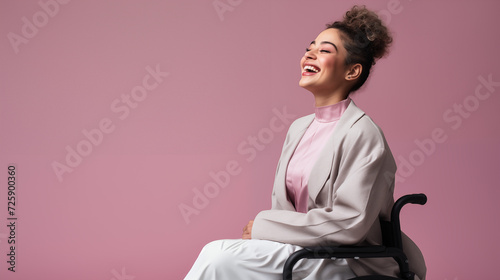 Beautiful disabled woman in a wheelchair smiling on a pink plain background