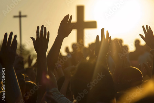 Christians with hands raised in praise, worship and prayer to God at sunrise