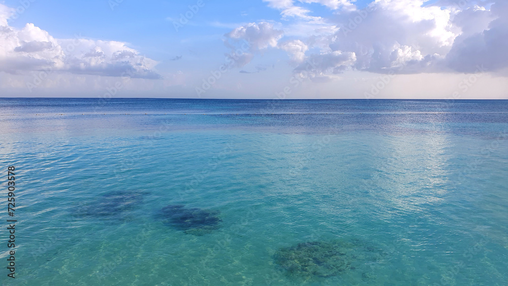 Tropical paradise beach with white clouds and blue caribbean sea.