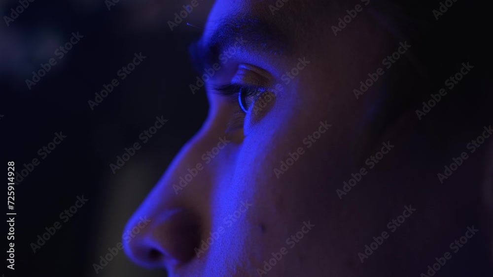 The light of the flashing lights is reflected on the man's face, close-up
