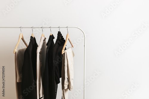 Modern rack with capsule collection in neutral black and beige colours. Beautiful minimalistic lifestyle with copy space for your text..