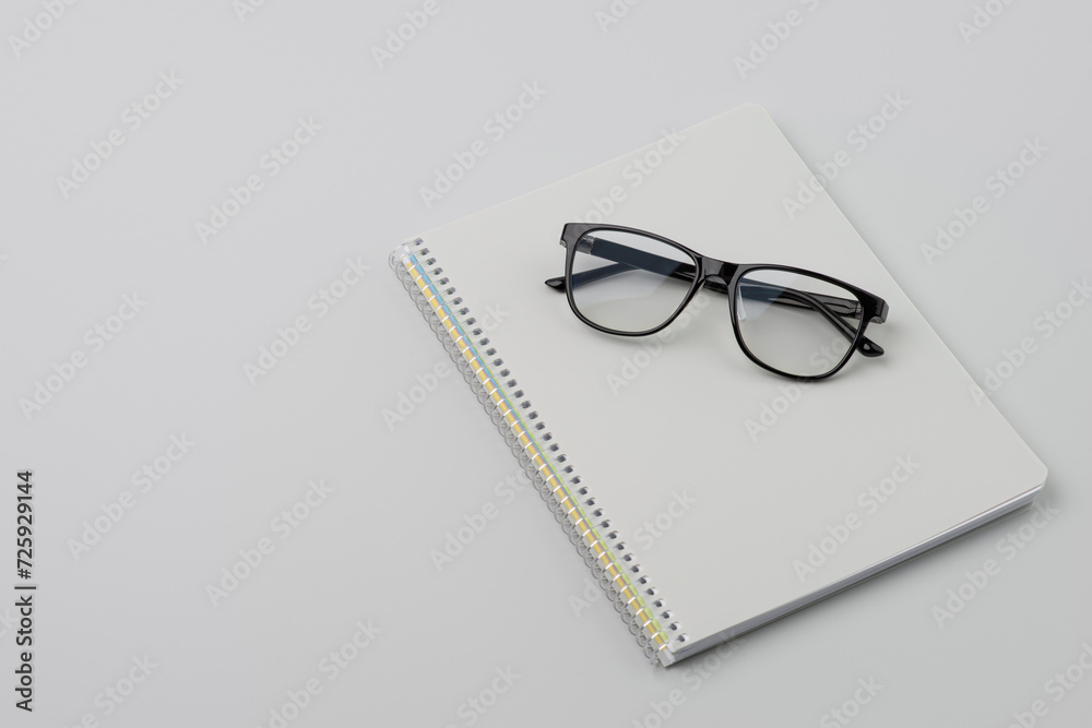 Glasses on a gray notepad lying on the table Glasses on a gray notepad lying on the table