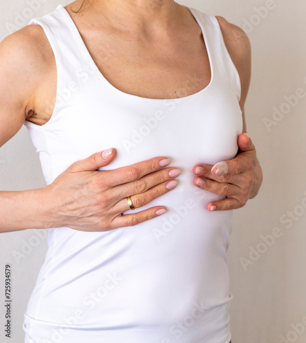 Wallpaper Mural Shot of the woman in the white top against the white wall, performing self examination of the breasts, looking for abnormalities. Breast cancer awareness Torontodigital.ca