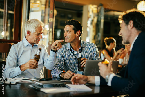 Group of business people having an after work beer in a cafe or bar photo