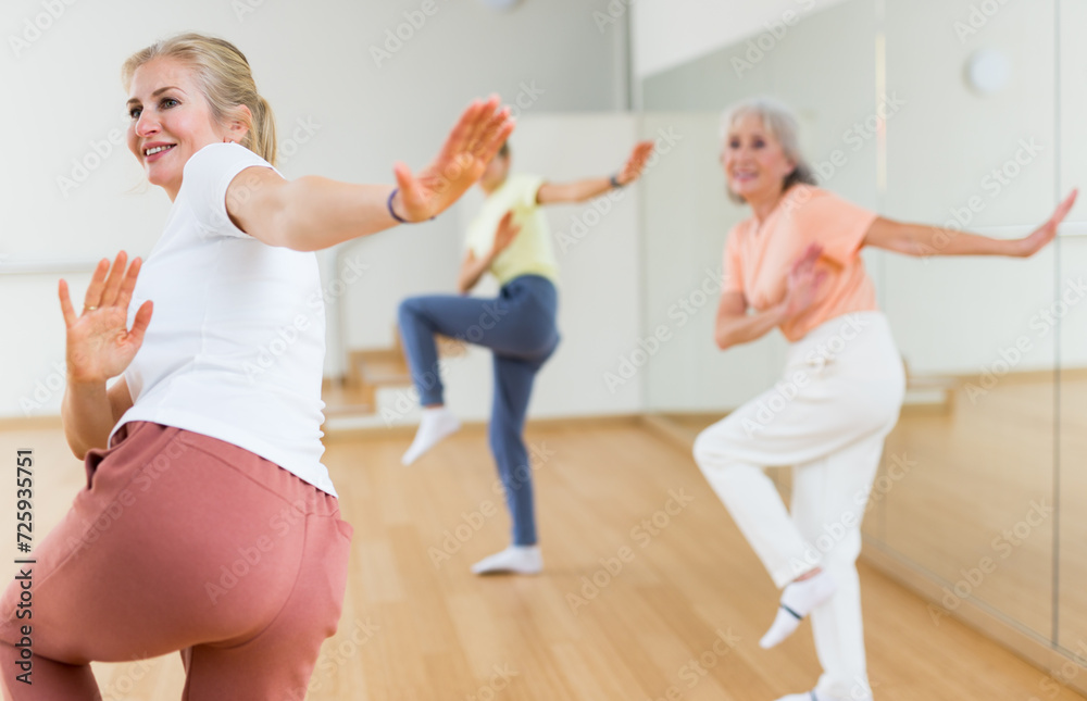 Fototapeta premium Modern positive active females dancing excited posing in studio