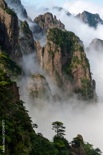 Misty clouds hover around Cloud Dispersing Pavillion s Boot Rock in the Yellow Mountains of China.