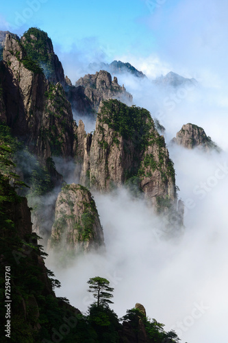 Misty clouds hover around Cloud Dispersing Pavillion's Boot Rock in the Yellow Mountains of China.