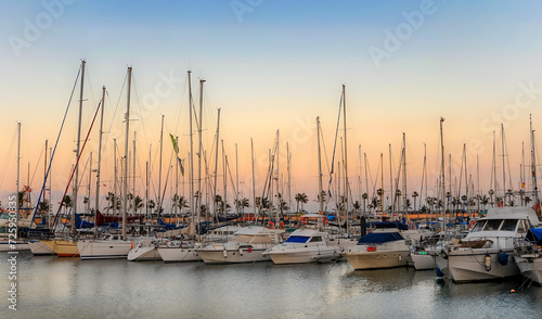 Marina at sunset in Las Palmas de Gran Canaria. Landscape with boats, sea and palm trees. Nautical concept, transportation, amateur sailing, vacation, recreation..