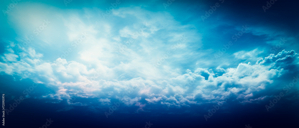Ethereal blue clouds with beams in dark navy and white. Realistic yet dreamlike, high-angle aerial view with strong contrast. Chiaroscuro skies create a national geographic photo atmosphere