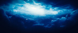 Ethereal clouds with blue light and beams, dark navy, and white hues. Realistic dreamlike horizons, aerial view, high contrast, chiaroscuro. Detail in a captivating, atmospheric shot