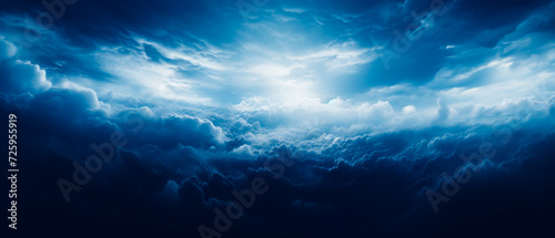 Ethereal clouds in dark navy and white  realistic dreamlike atmosphere. Aerial view with strong contrast  chiaroscuro effect. Blue clouds above a dark sky  worthy high detail