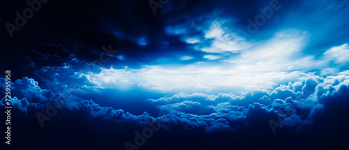 Ethereal blue clouds with beams in dark navy and white. Realistic  dreamlike atmosphere in high-angle aerial view. Chiaroscuro effect  strong contrast  quality