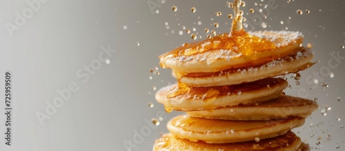 Pancakes with texture are airborne against a white backdrop, using selective focus.
