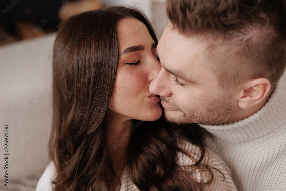 happy young couple in love is hugging, kissing and smiling together celebrating Valentine's day at home. Man and woman enjoying spending time together, relaxing on date happy young couple in love is hugging, kissing and smiling together celebrating Valentine's day at home. Man and woman enjoying spending time together, relaxing on date