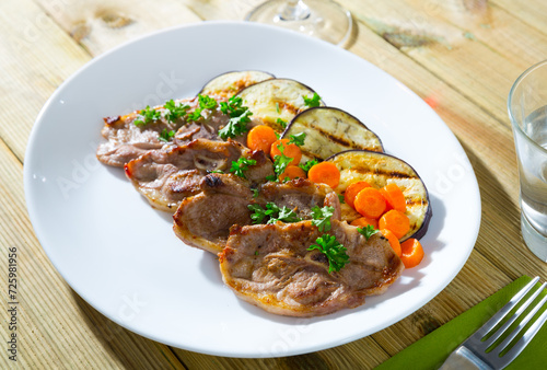 Delicious slices of roasted lamb meat served with grilled eggplant, carrot and herbs