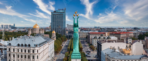Beautiful sunrise view over Riga by the statue of liberty - Milda in Latvia. The monument of freedom. photo
